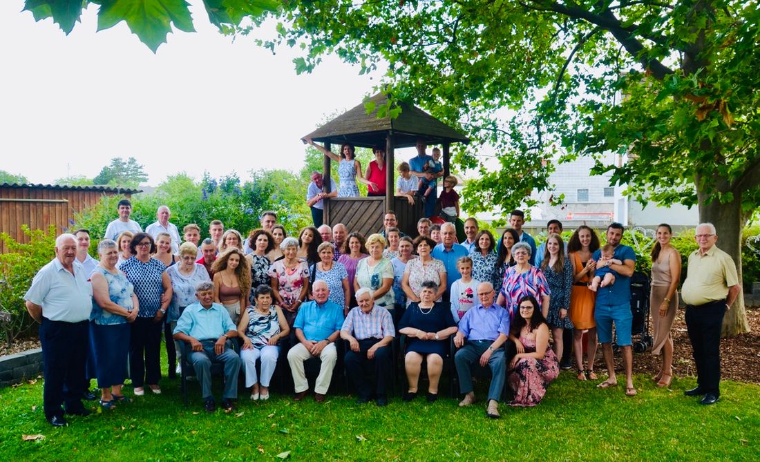 A large family gathered for a group photo in a garden in Austria, from grandparents to a baby