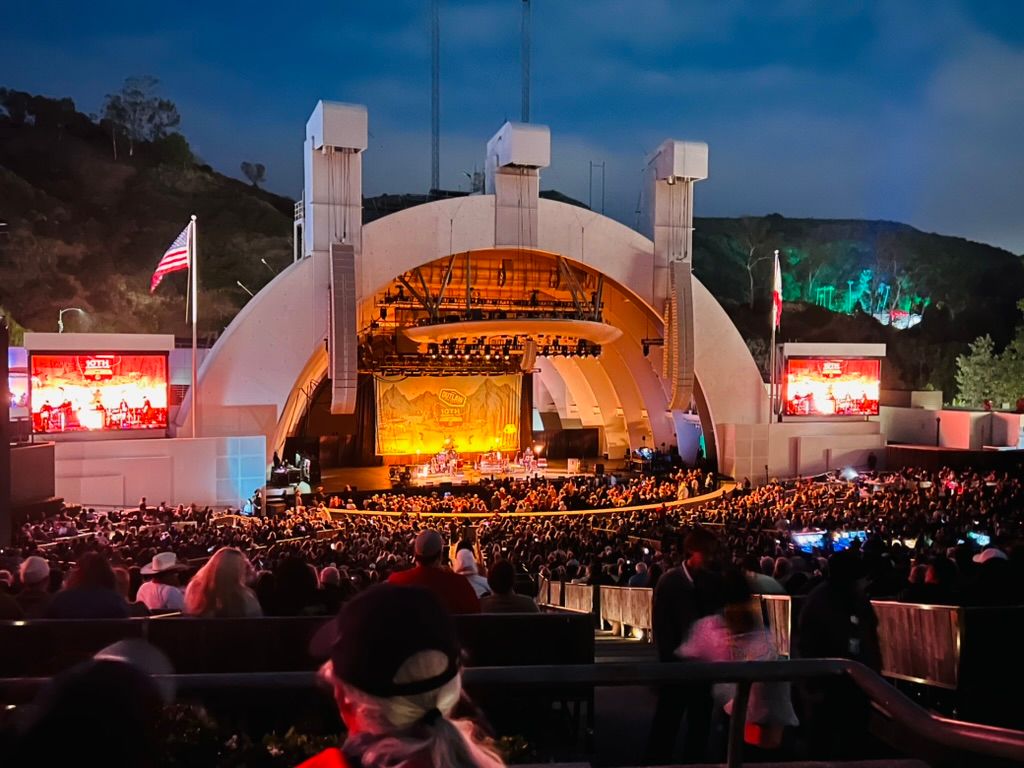 A full Hollywood Bowl at dusk, the band shell lit up and the hills behind it