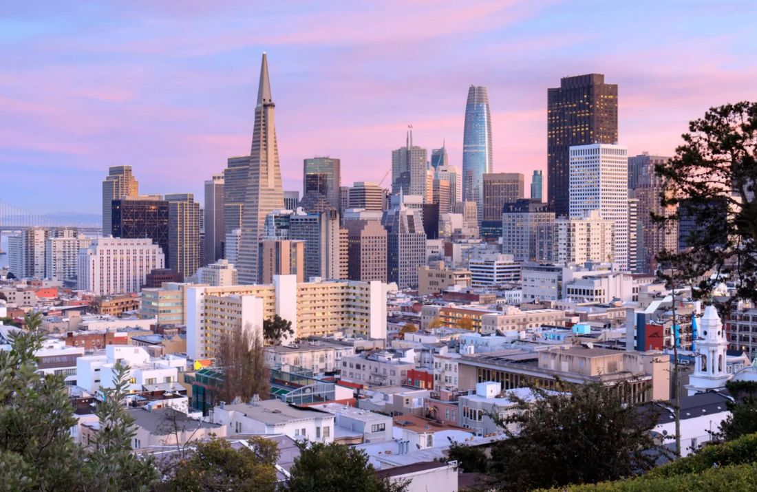 San Francisco’s skyline under a pink sky, the Transamerica Pyramid and Salesforce Tower above the rooftops